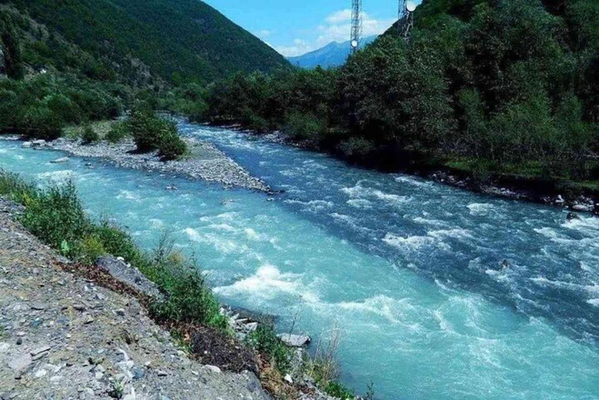 ένα ποτάμι με γαλάζια νερά και δέντρα στο πλάι
