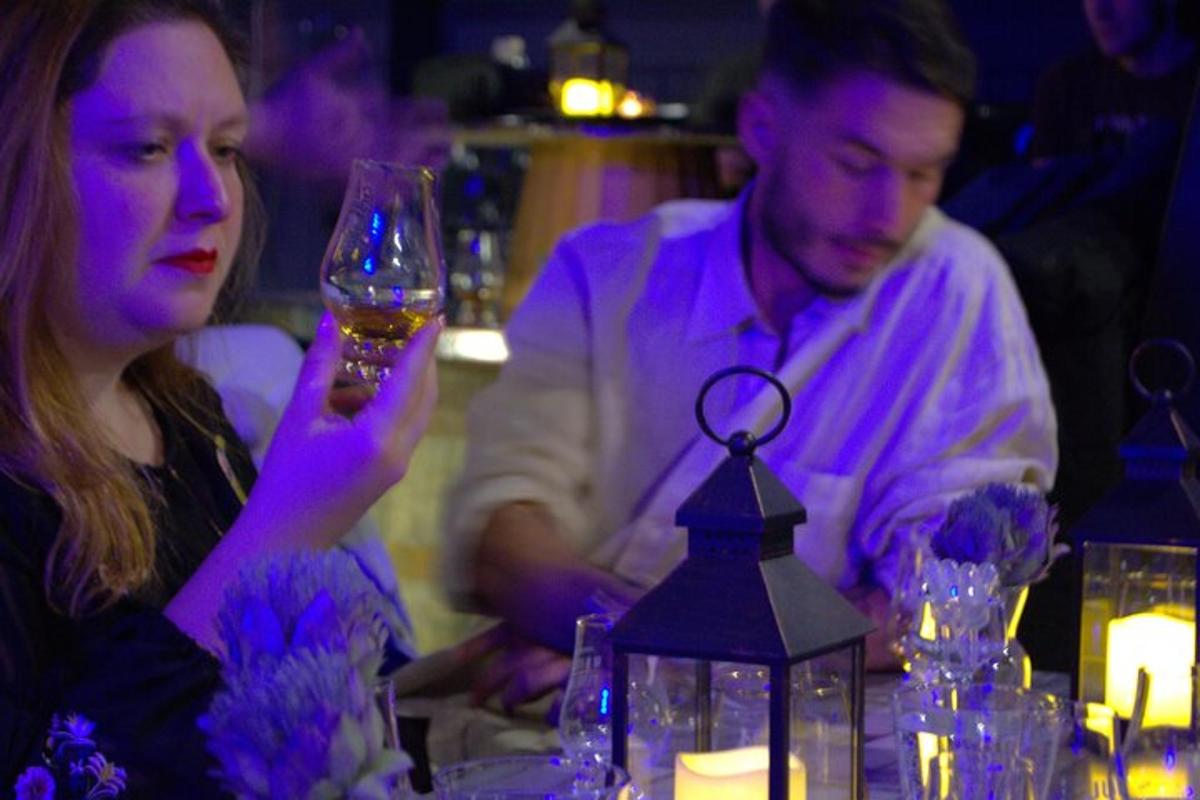 un bărbat și o femeie așezați la o masă cu un pahar de vin