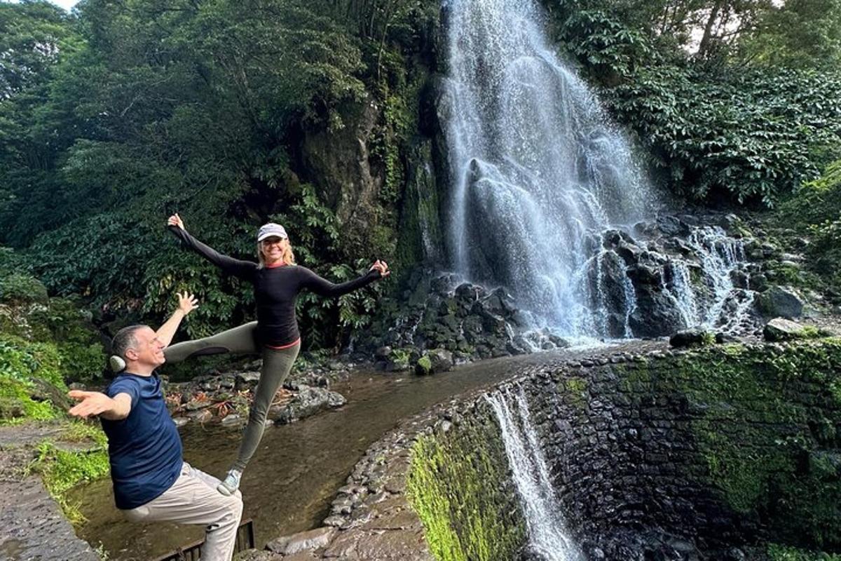 un homme et une femme debout devant une cascade