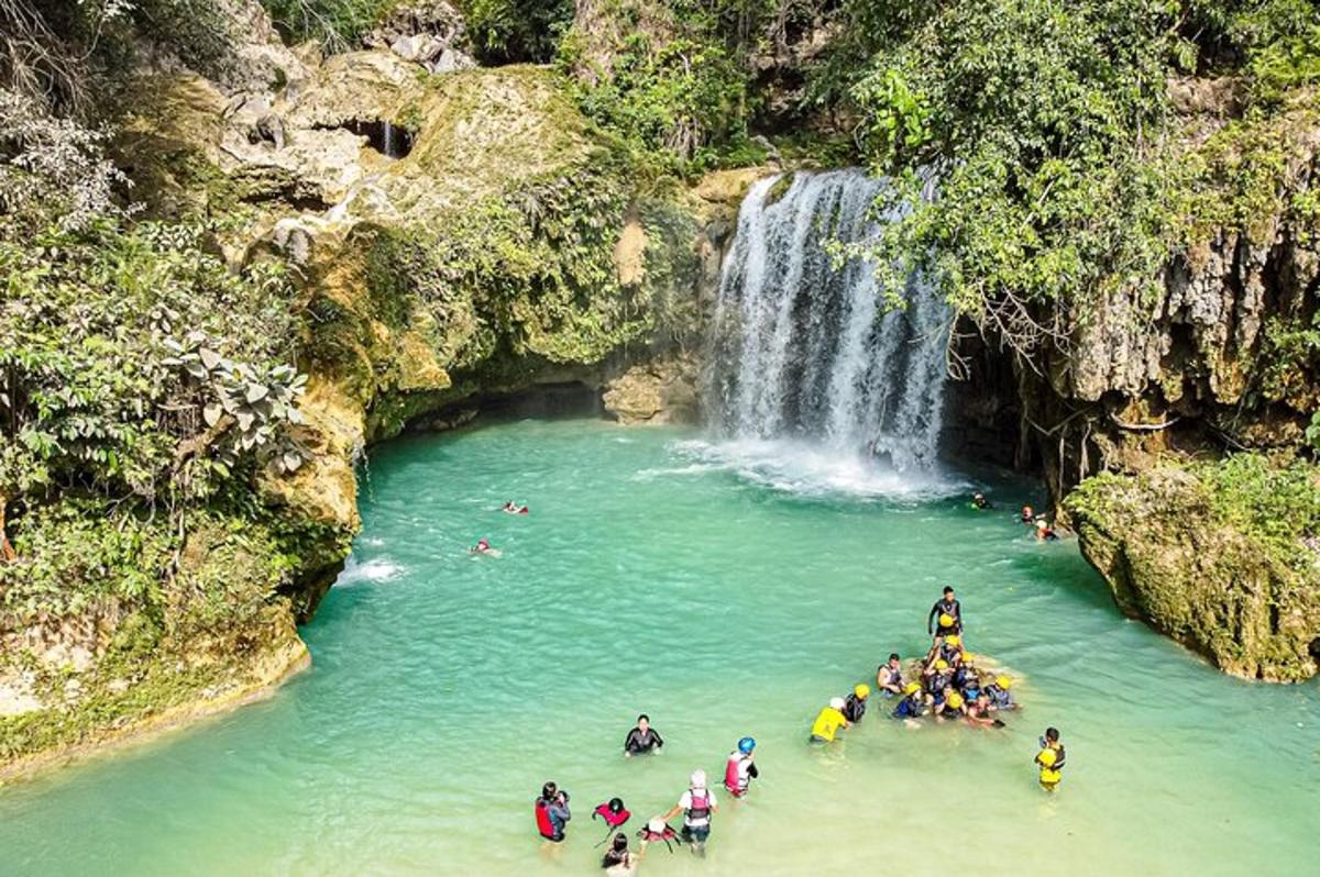 isang grupo ng mga tao sa tubig malapit sa isang talon
