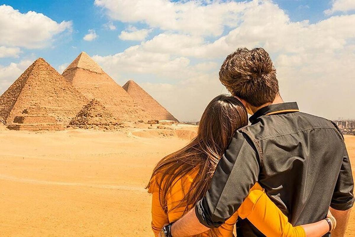 muž a žena stojící před pyramidami