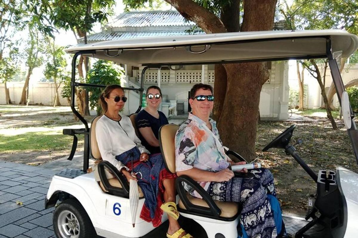 tre persone sono sedute su un golf cart
