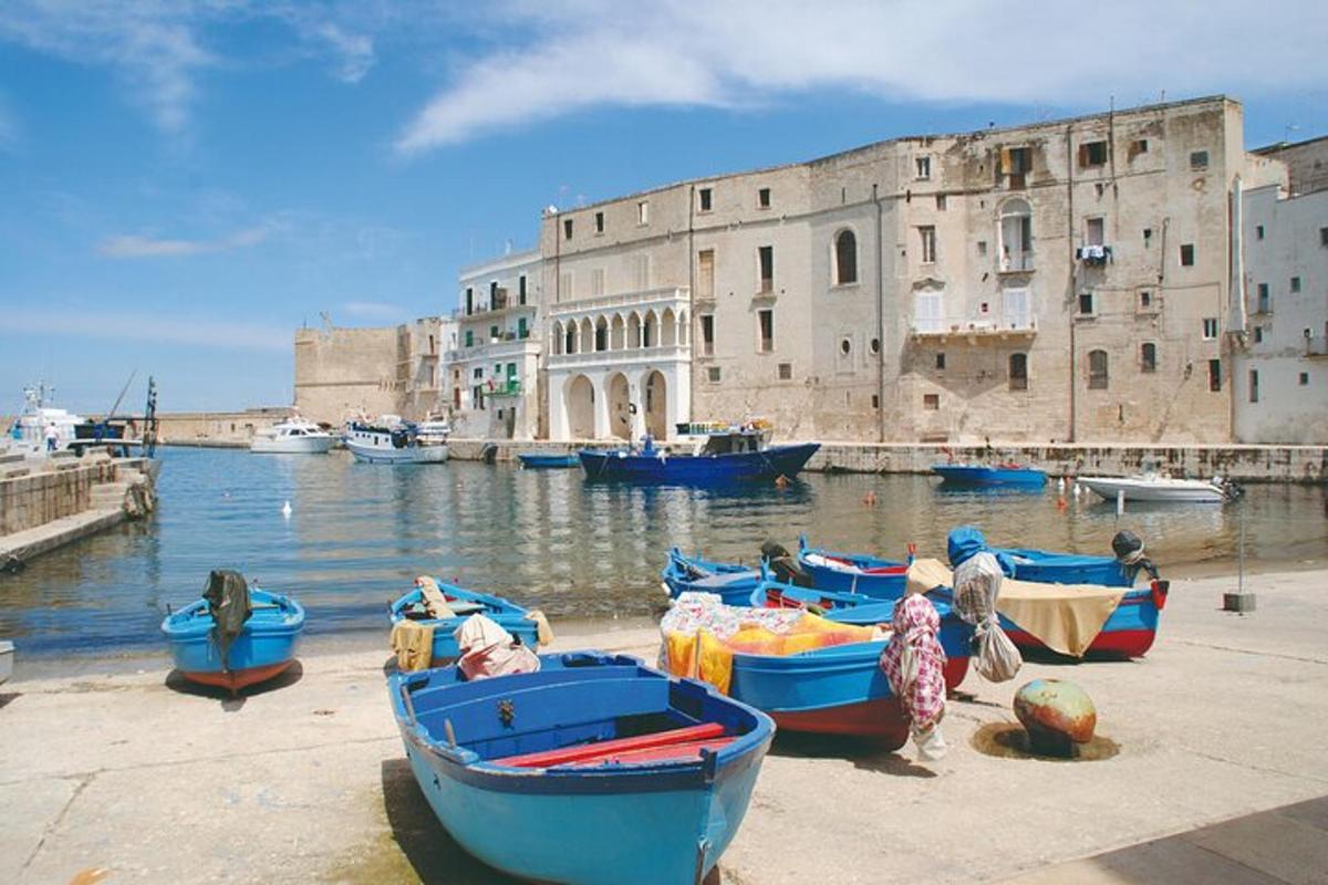 Un grupo de barcos en el agua junto a un edificio.