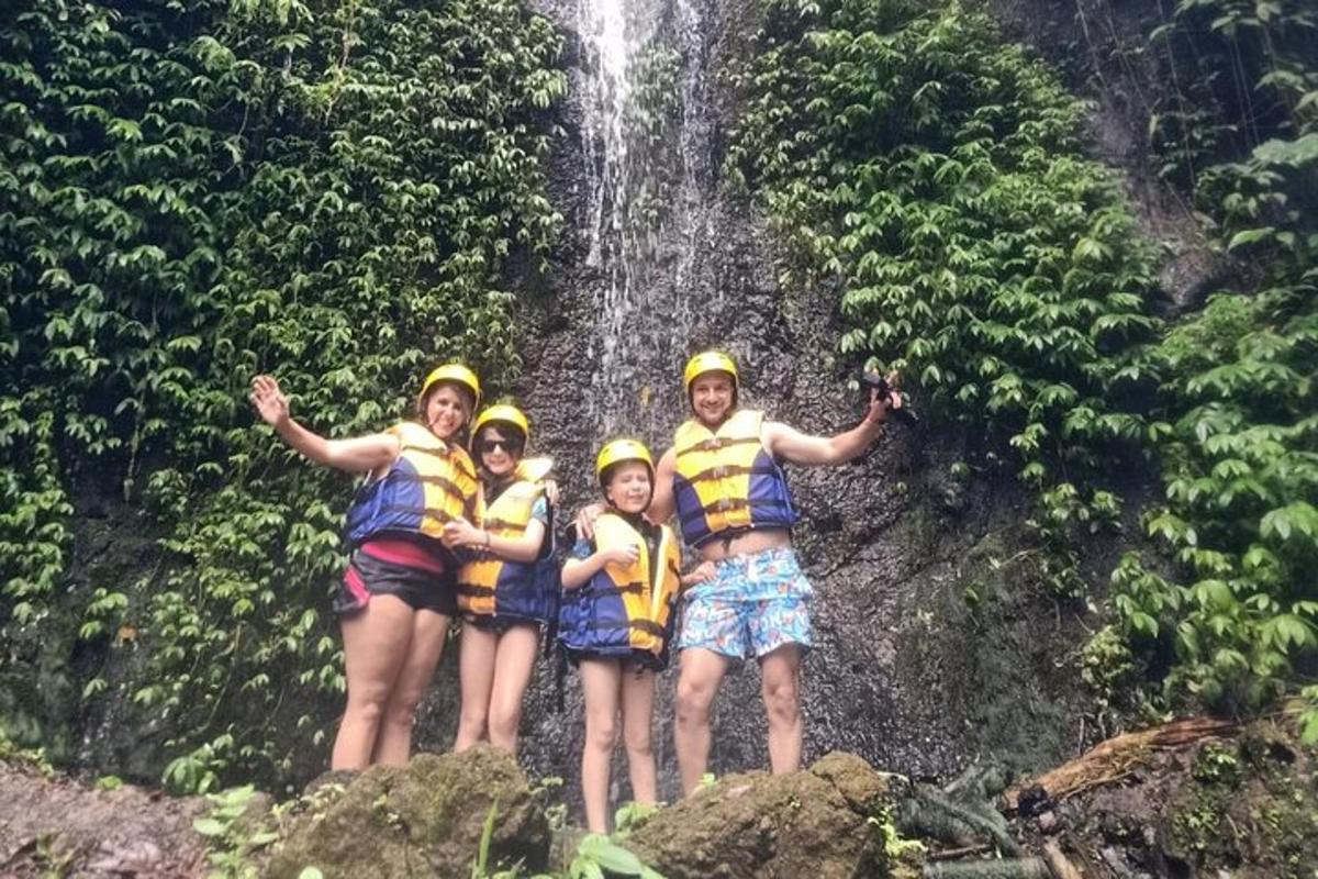 un gruppo di persone in piedi davanti a una cascata