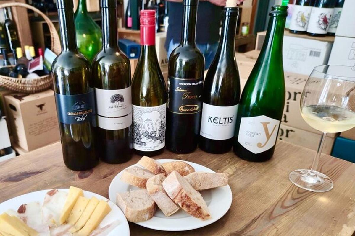 miza, obložena s steklenicami vina in krožniki sira