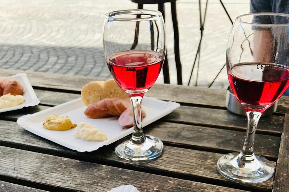 kozarec vina in krožnik hrane na mizi