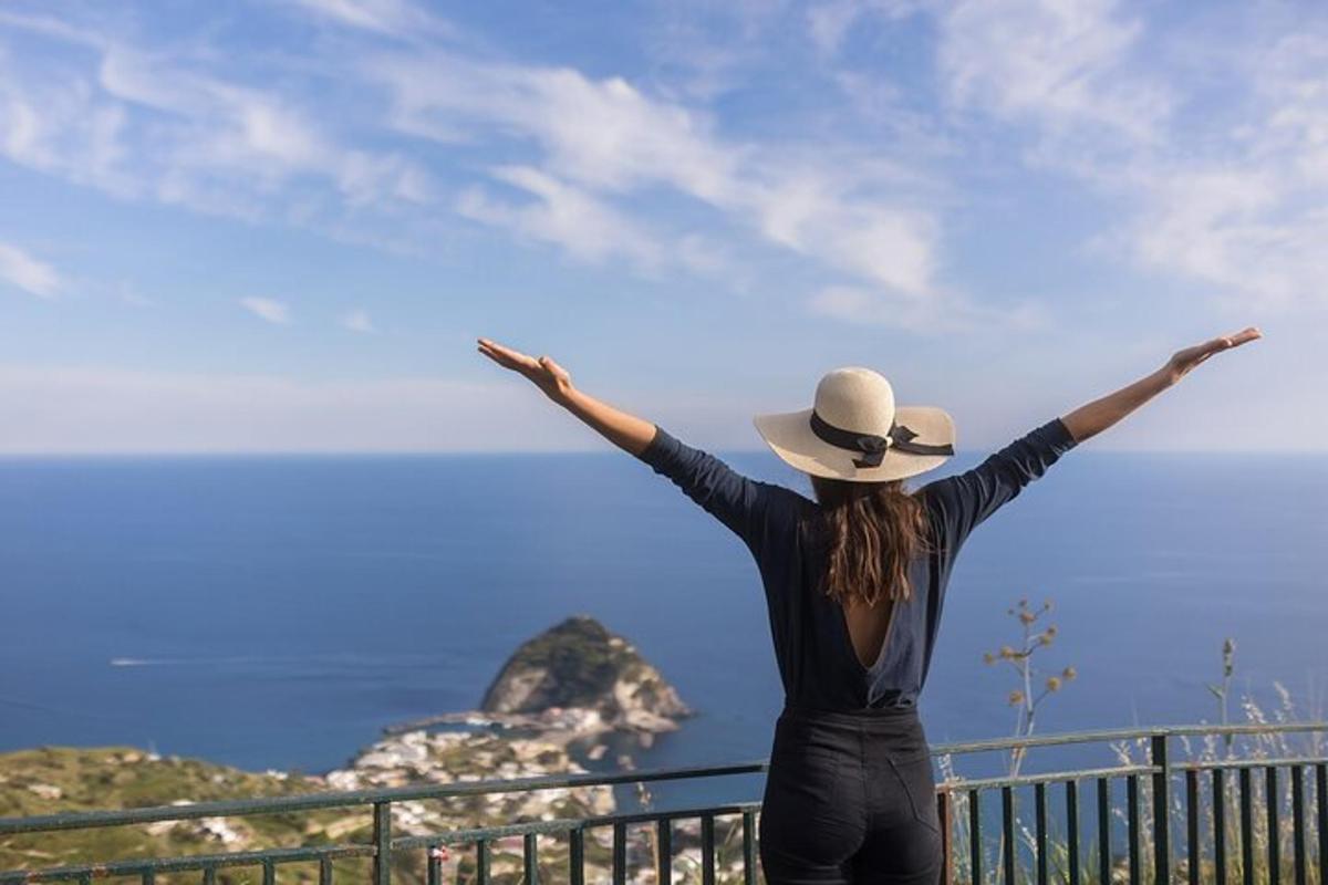 una donna con le braccia tese che guarda l'oceano