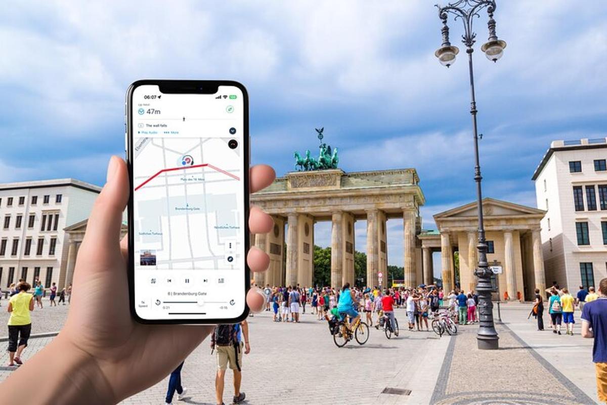 osoba držící mobilní telefon před městem