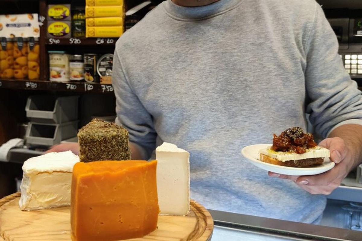 Un hombre sosteniendo un plato de diferentes tipos de queso.