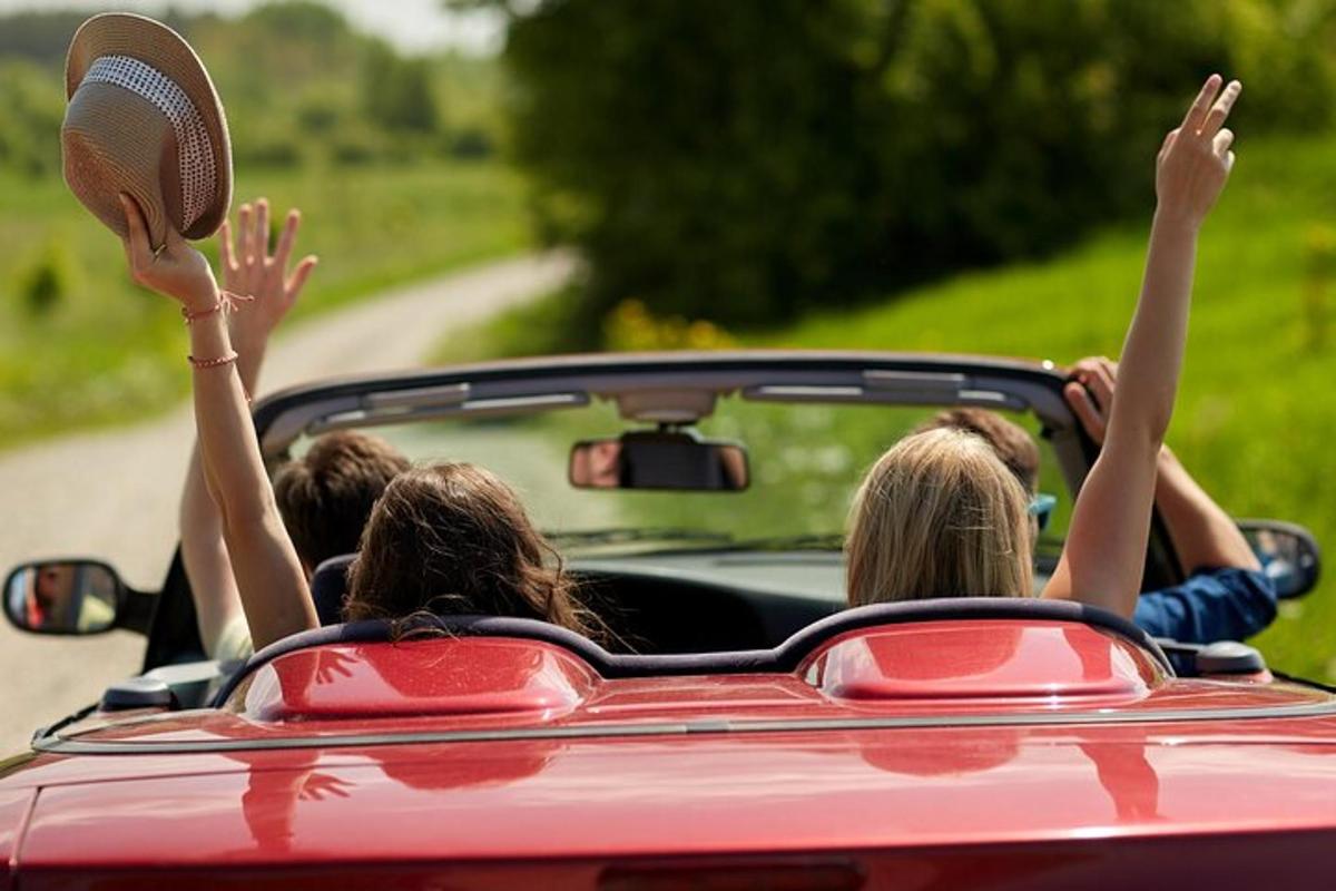 a group of people in a car with their arms up