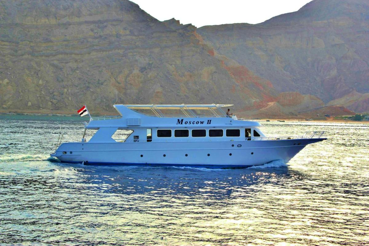 um barco na água com uma montanha ao fundo