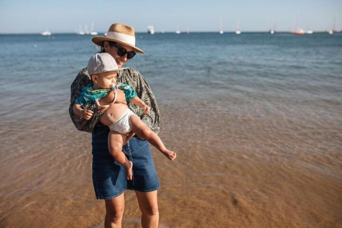 un uomo che tiene in braccio un bambino sulla spiaggia