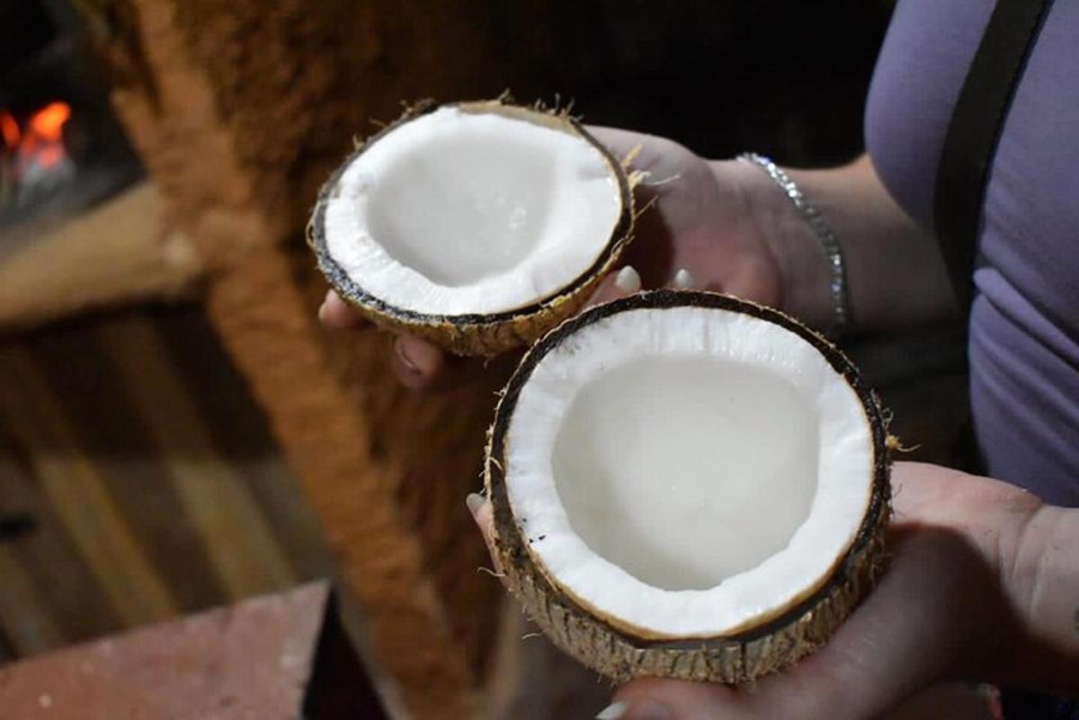 a person holding two halves of a coconut in their hands