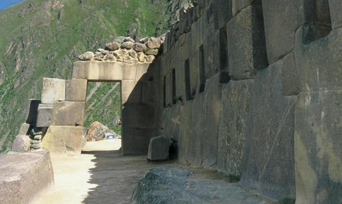 um muro de pedra com um túnel em uma montanha