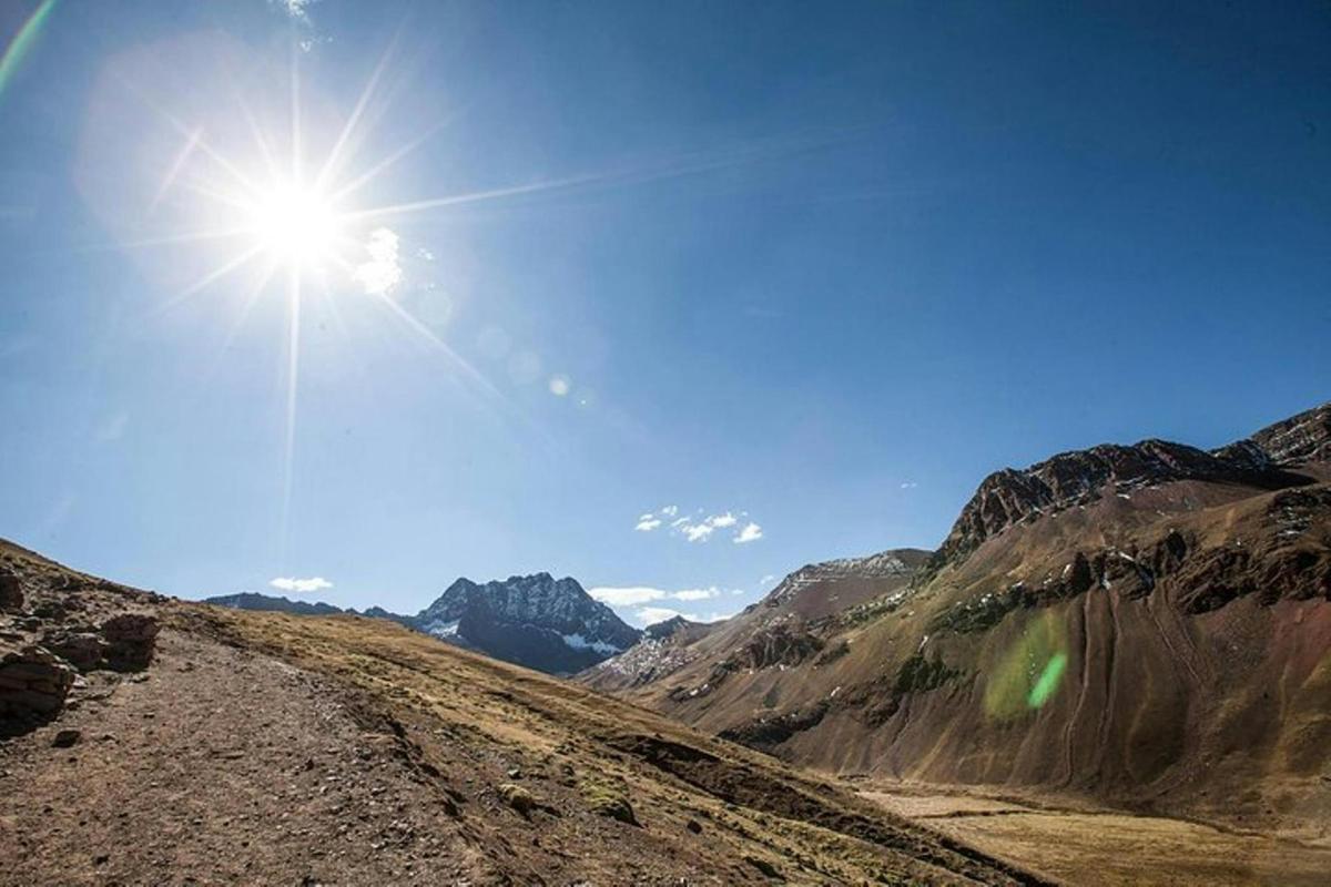 un sole che splende su una strada sterrata in montagna