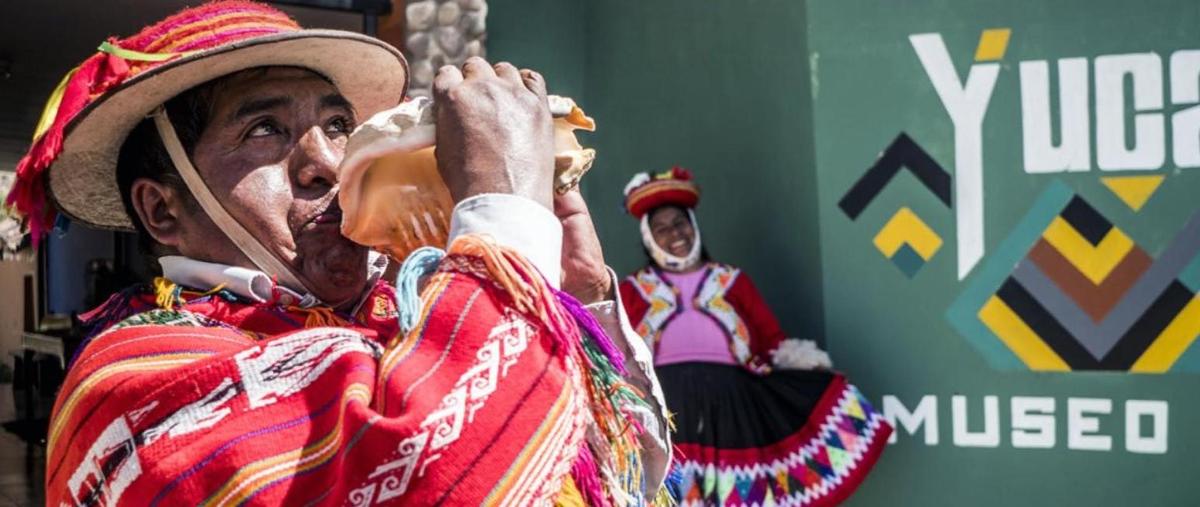 um homem com uma roupa colorida bebendo de uma garrafa