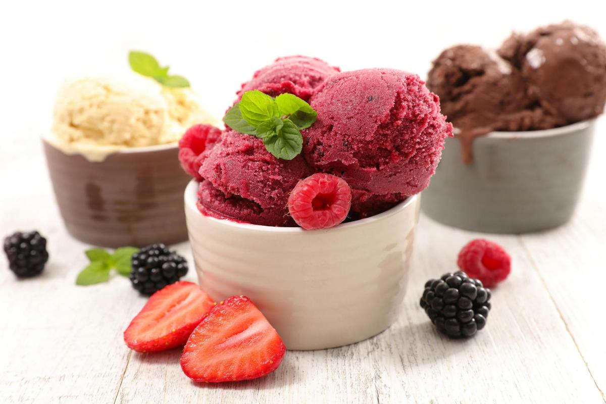 tre coppe di gelato con fragole e more
