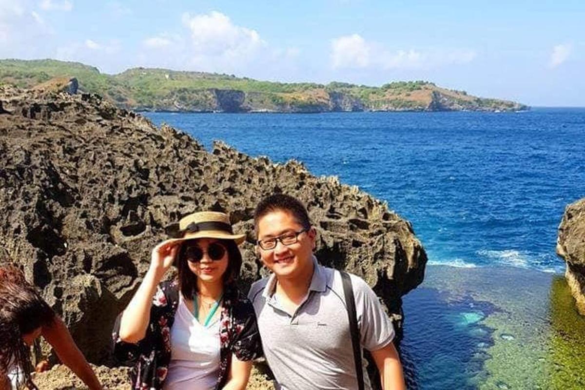 a man and a woman standing on a rocky beach