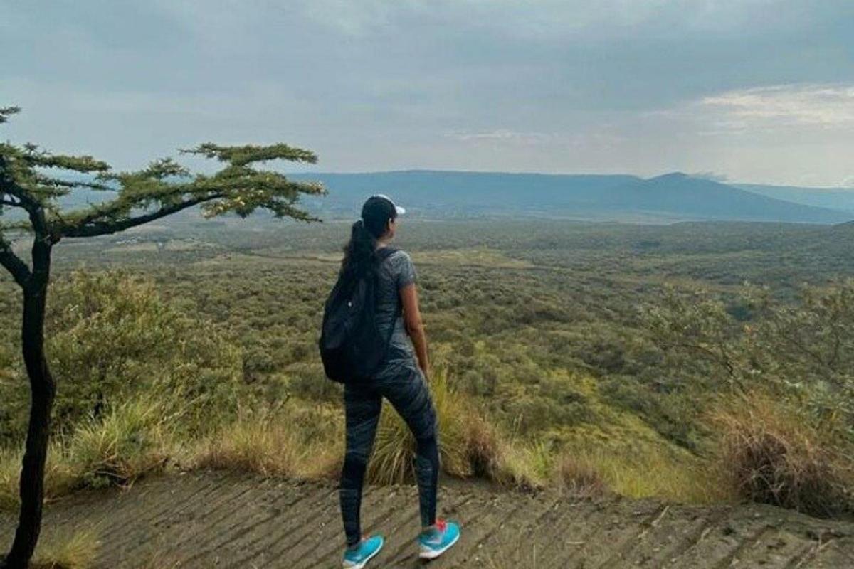 una persona con una mochila parada en la cima de una colina