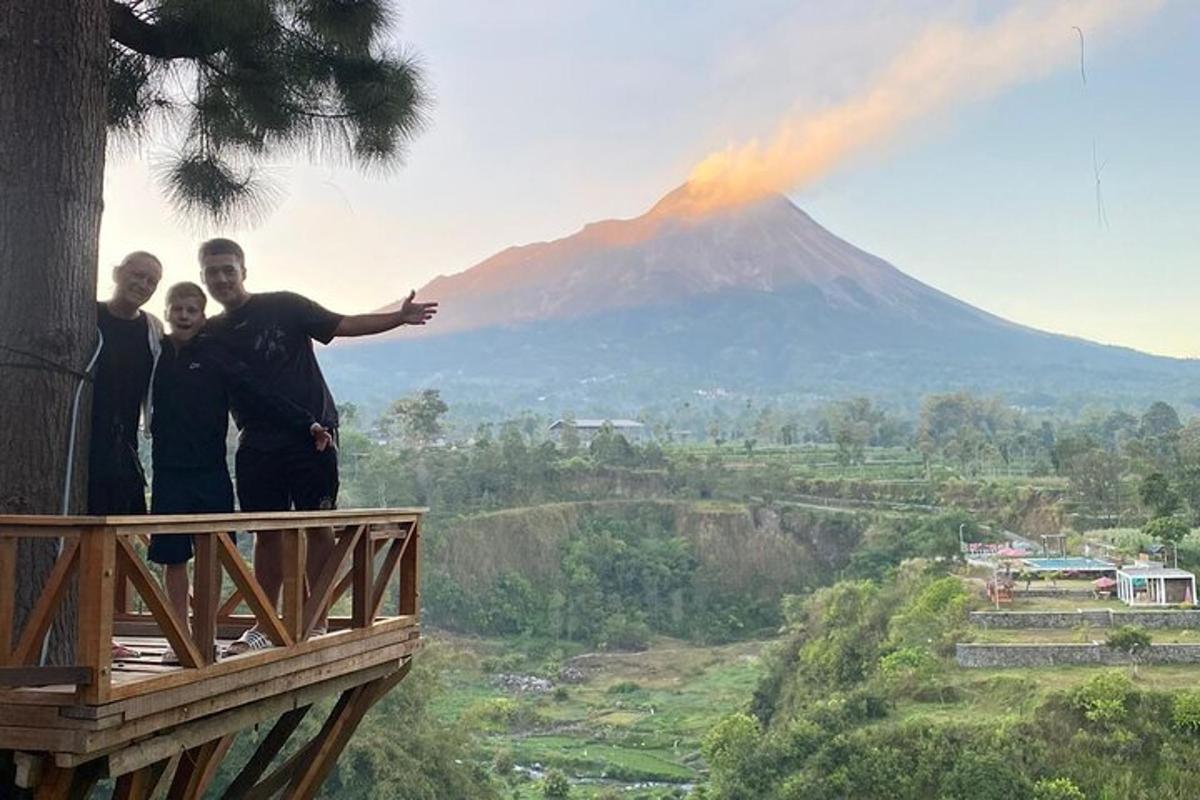 sekelompok tiga pria berdiri di balkon sambil memandangi gunung