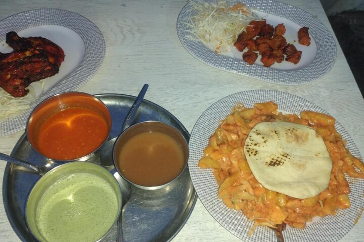 a table with three plates of food and sauce