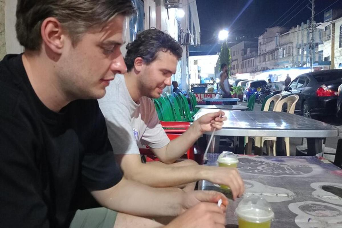 two men sitting at a table with drinks