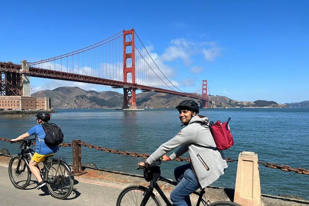 Dva lidé jedoucí na kolech před mostem Golden Gate