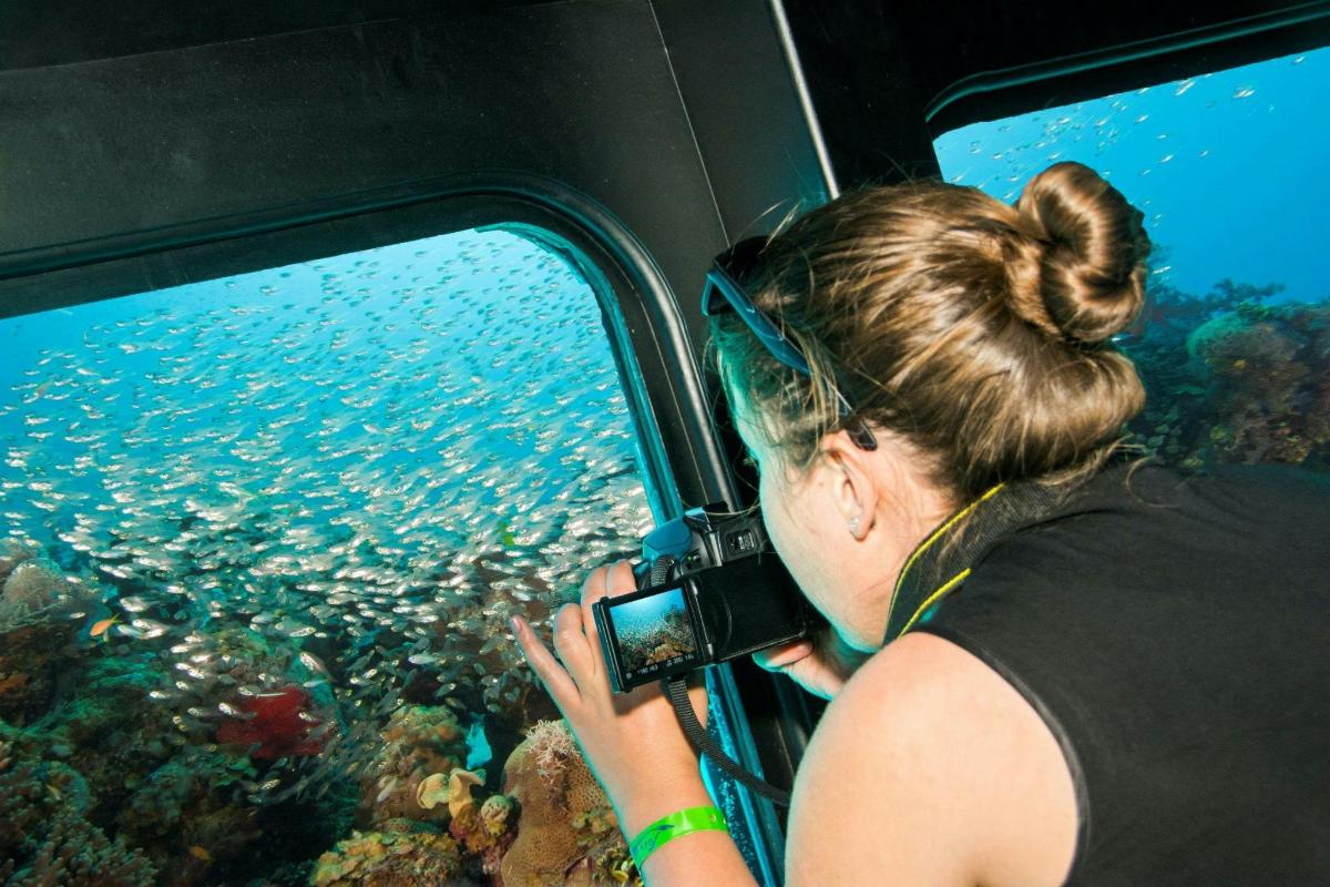 sieviete ar kameru fotografē okeānu