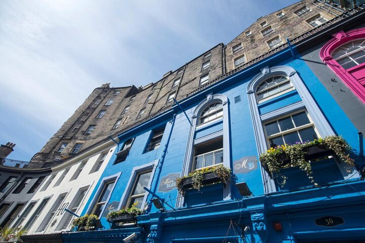 Un edificio azul con ventanas y plantas en macetas.