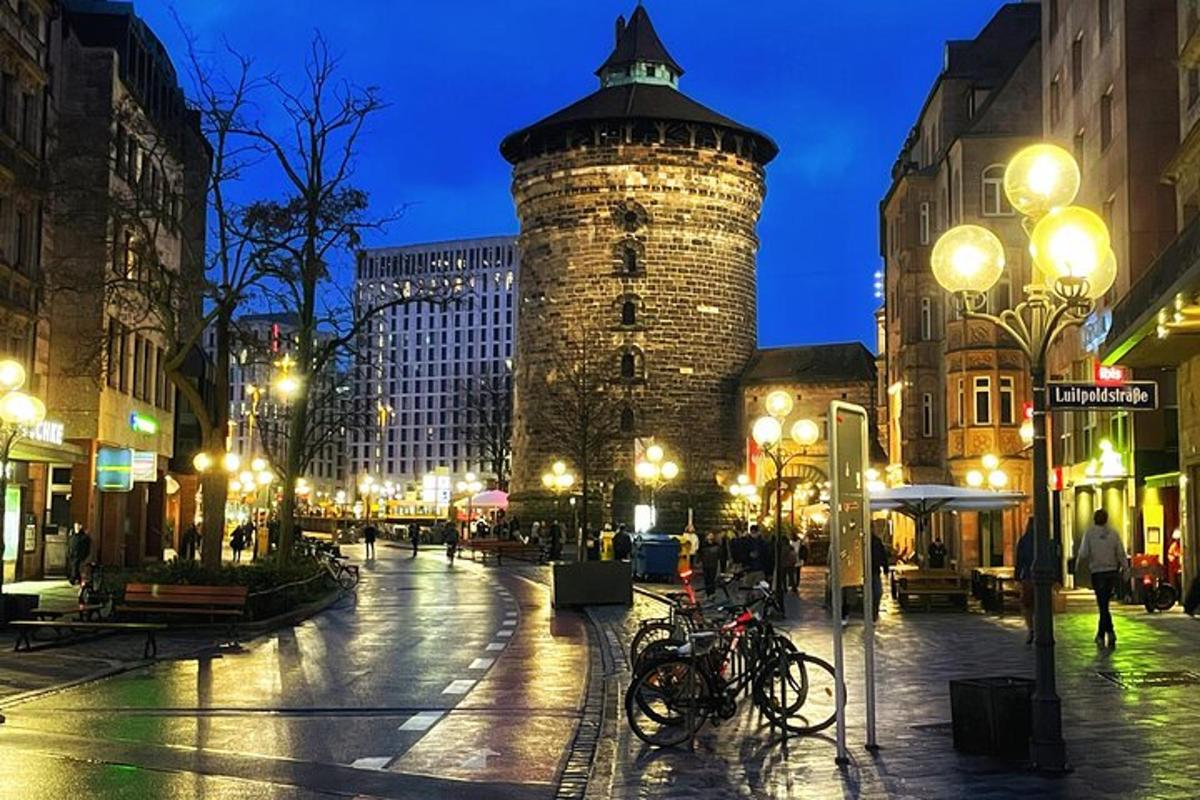 a city street at night with a tall tower