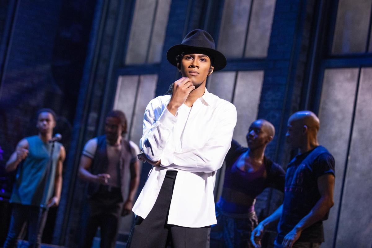 a man in a hat standing on a stage