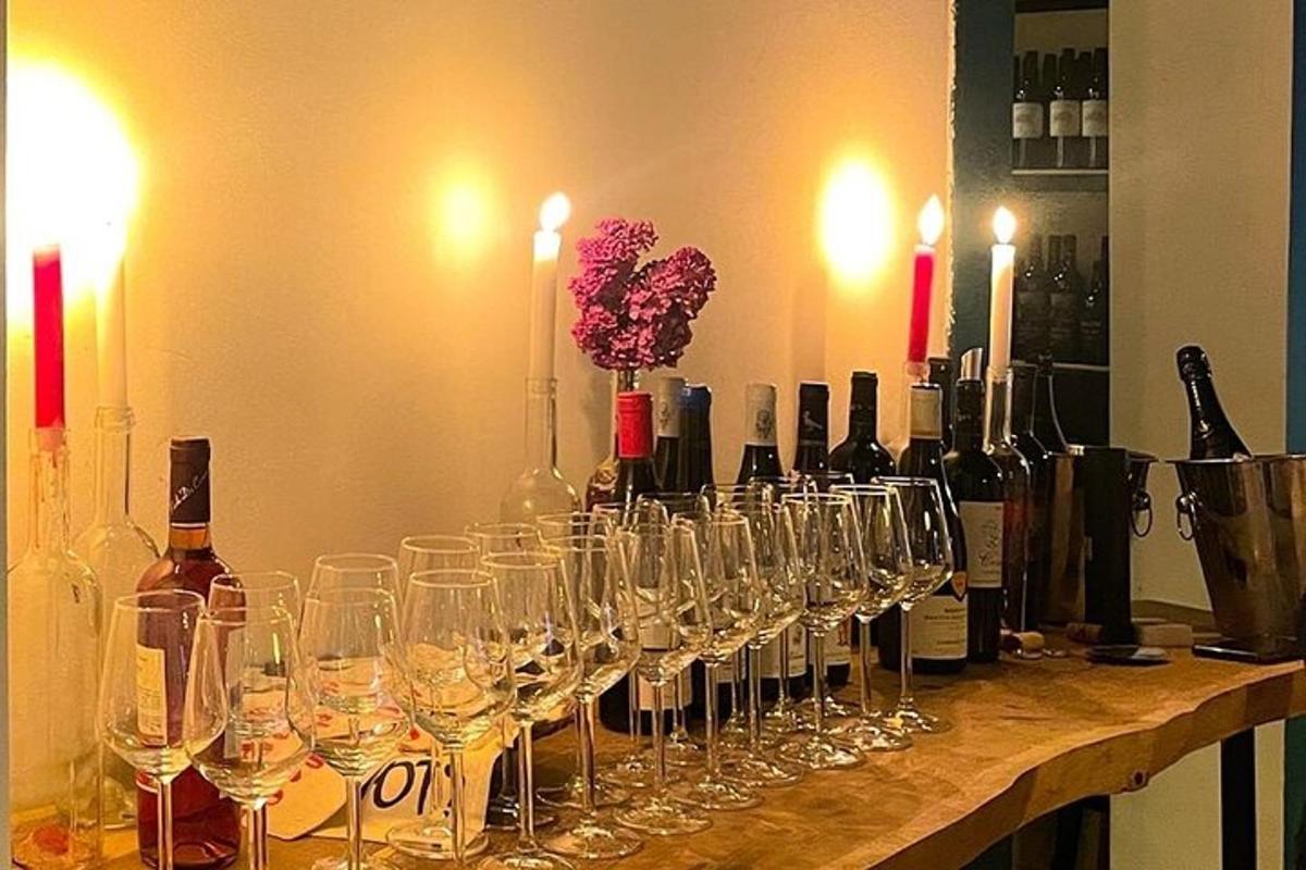 kup vinskih kozarcev, ki stojijo na mizi z vinskimi steklenicami