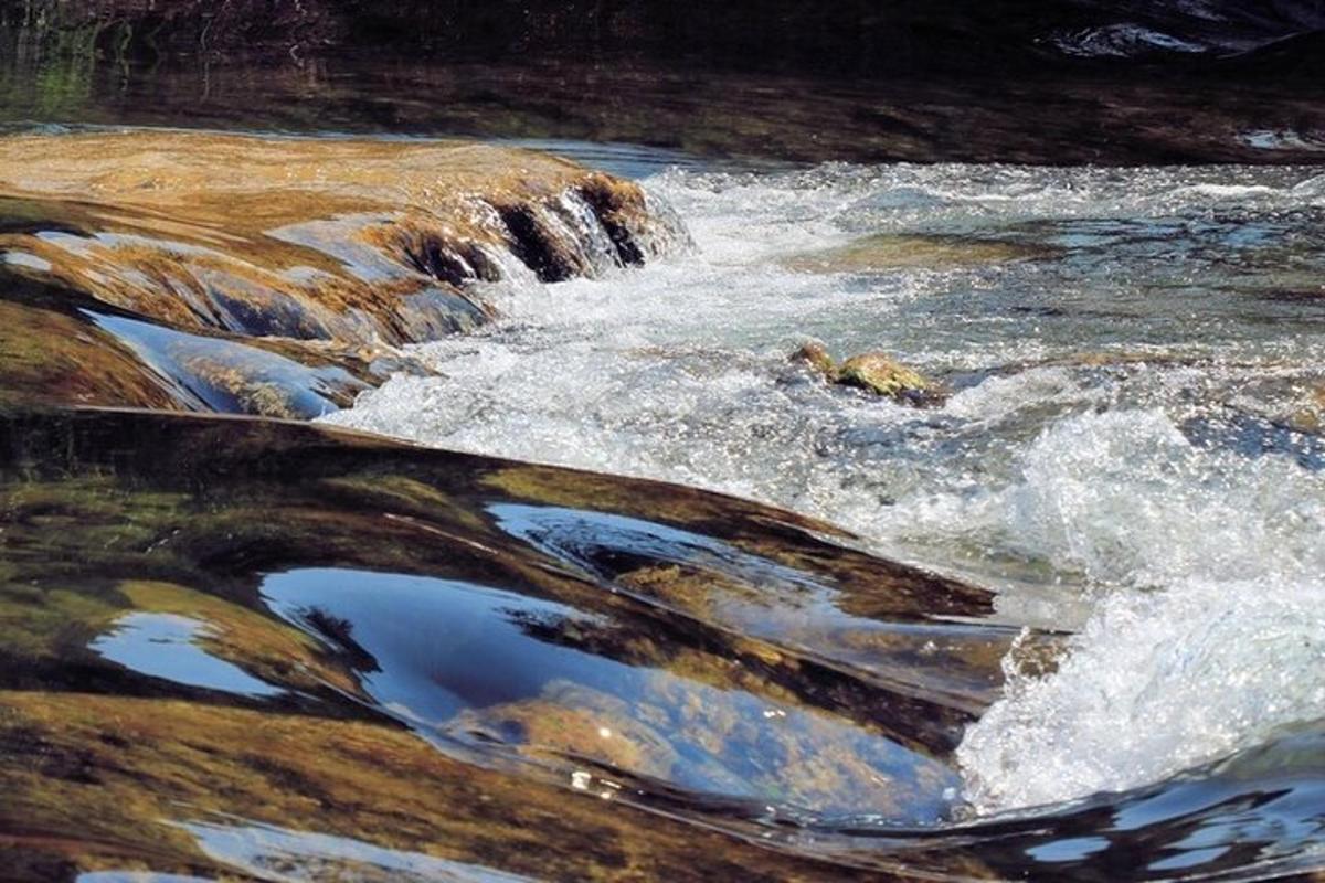 a stream of water with rocks and rushing water