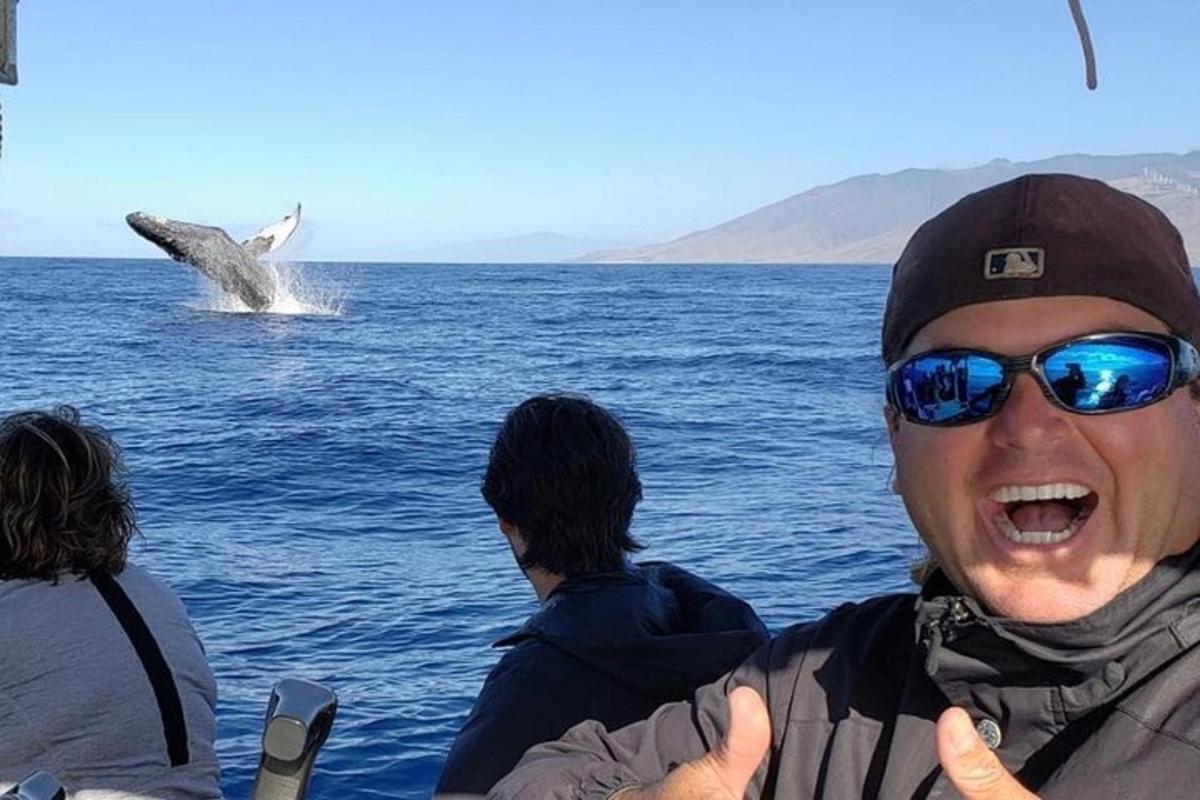 un hombre en un barco con una ballena en el agua