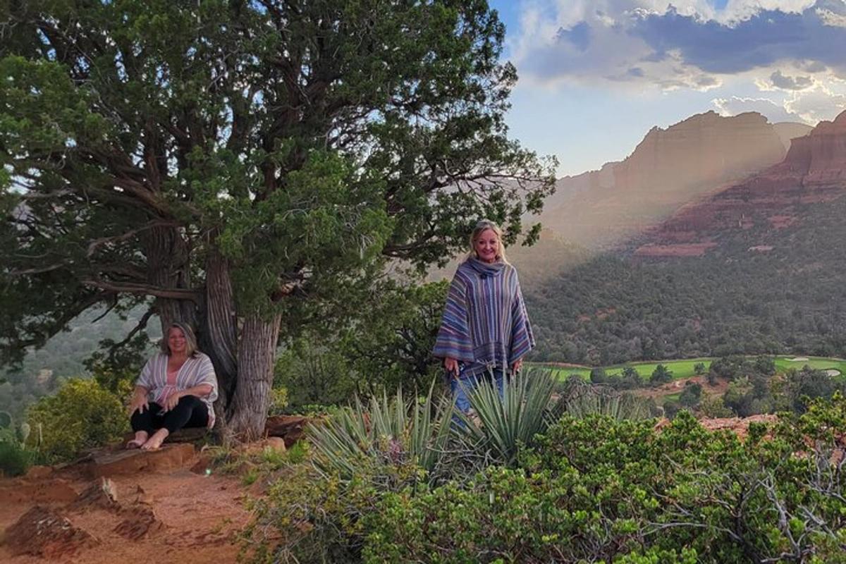 Dos mujeres de pie en una colina con vistas al Gran Cañón.