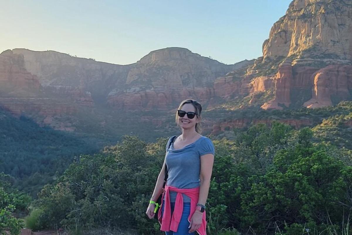 uma mulher em pé no topo de uma montanha
