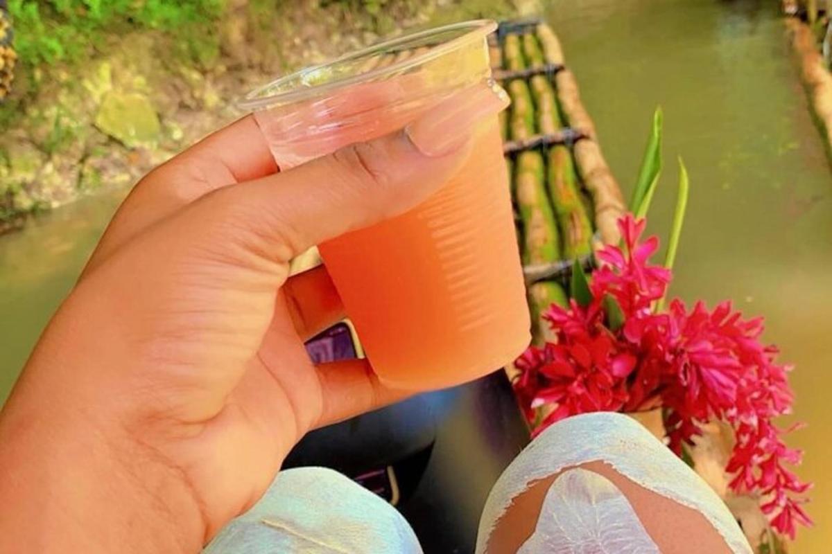 inimene, kes hoiab käes oranži vedelikuga täidetud plasttopsi