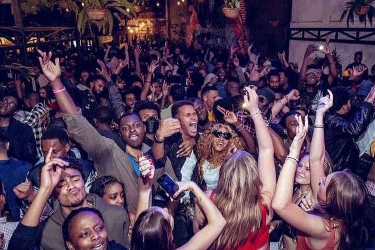 a crowd of people raising their hands in the air
