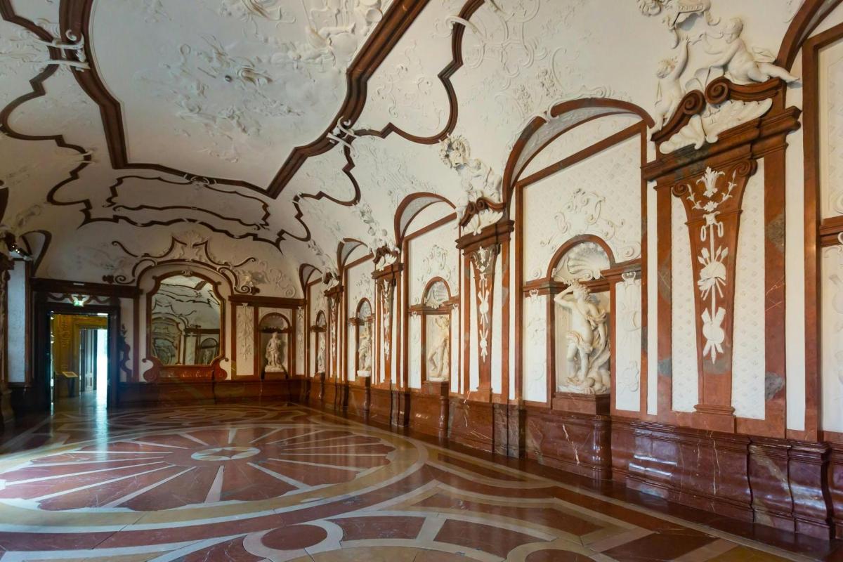 an ornate room with a painting on the wall