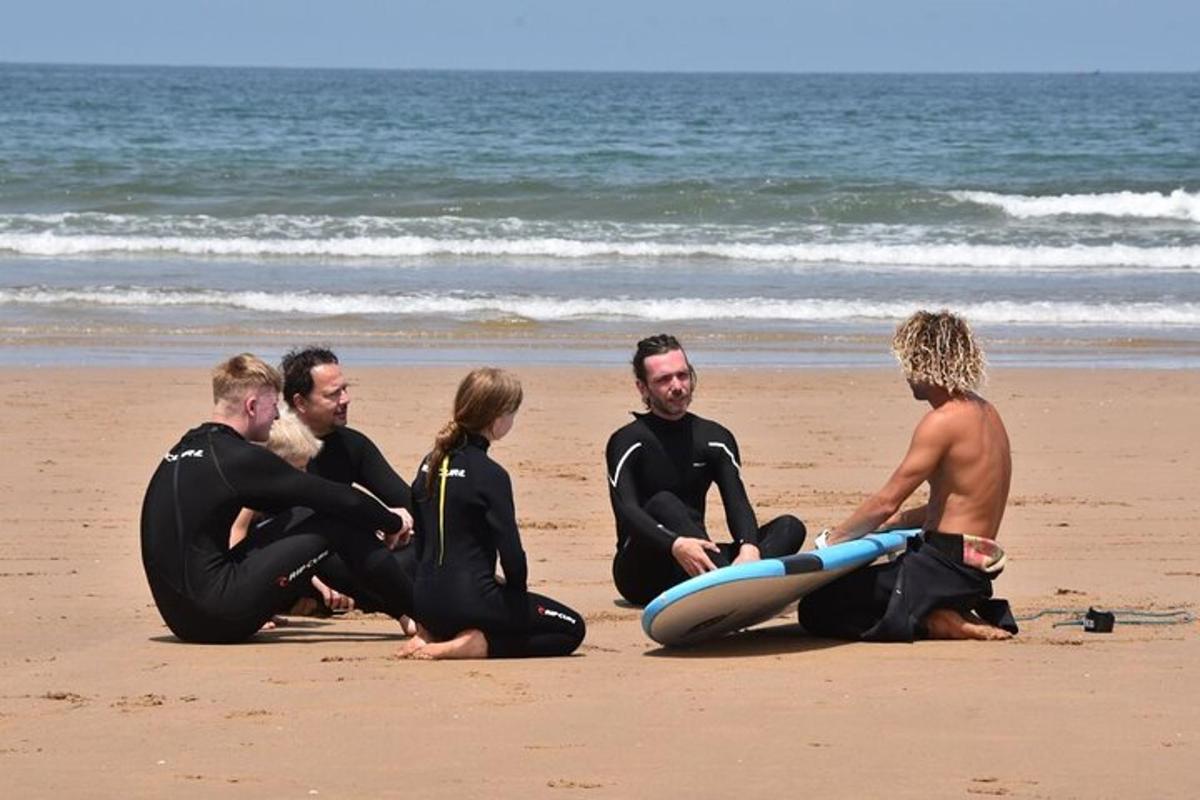 a group of people sitting on the beach with surfboards