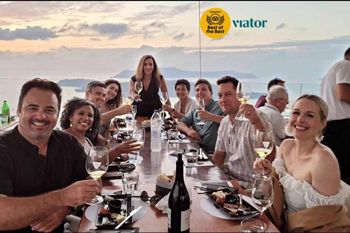 eine Gruppe von Menschen sitzt mit Weingläsern um einen Tisch