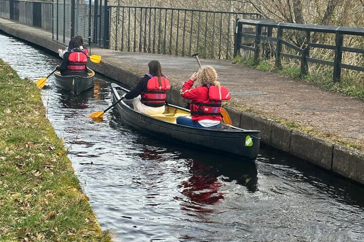 Tres personas están en una canoa en un canal