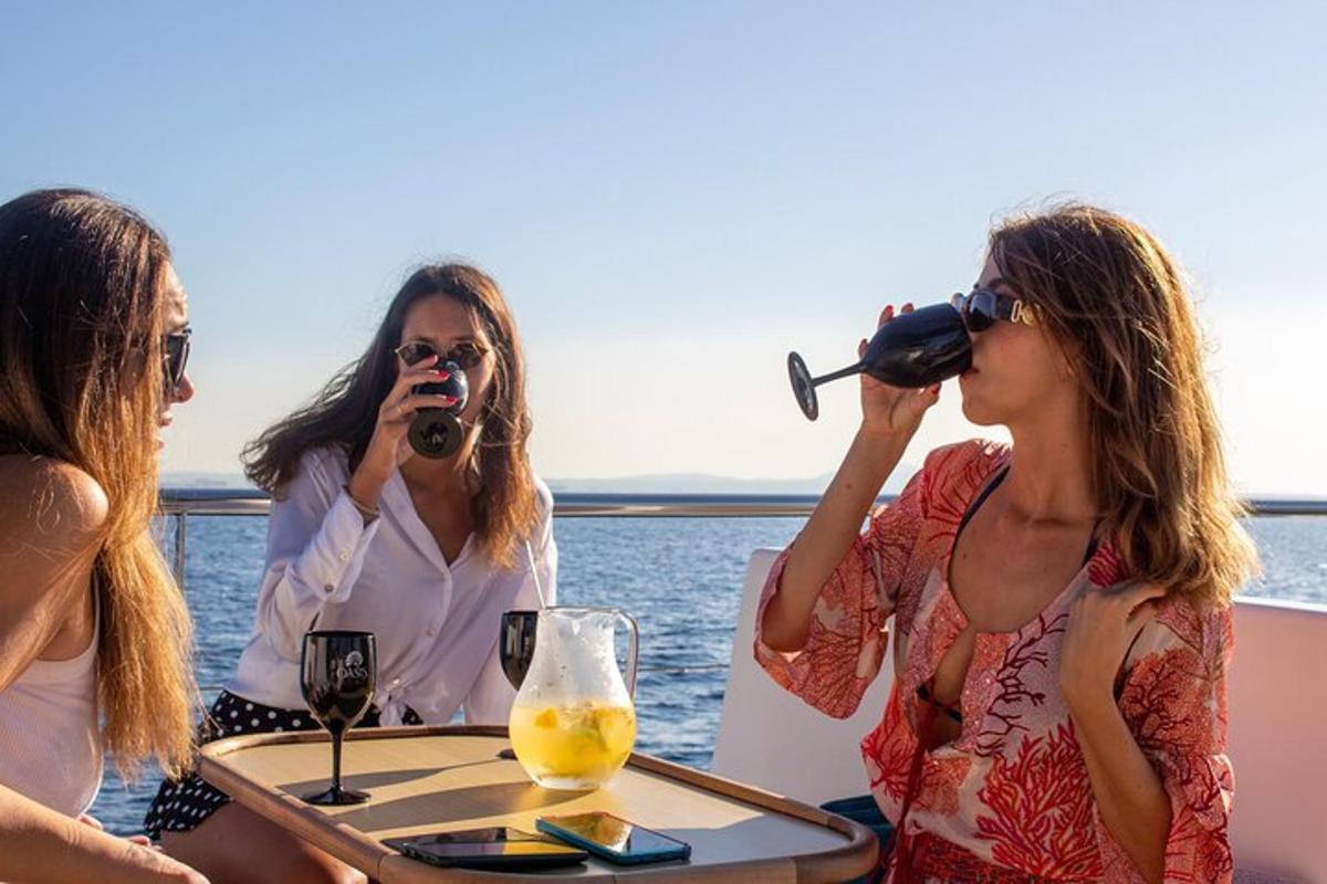tri ženske pijejo vino za mizo na ladji