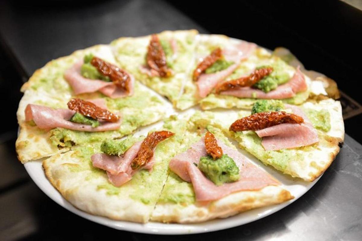 o pizza cu șuncă și broccoli pe o farfurie