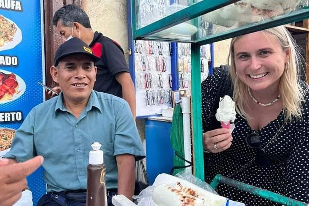 una donna in piedi accanto a un uomo che mangia un gelato