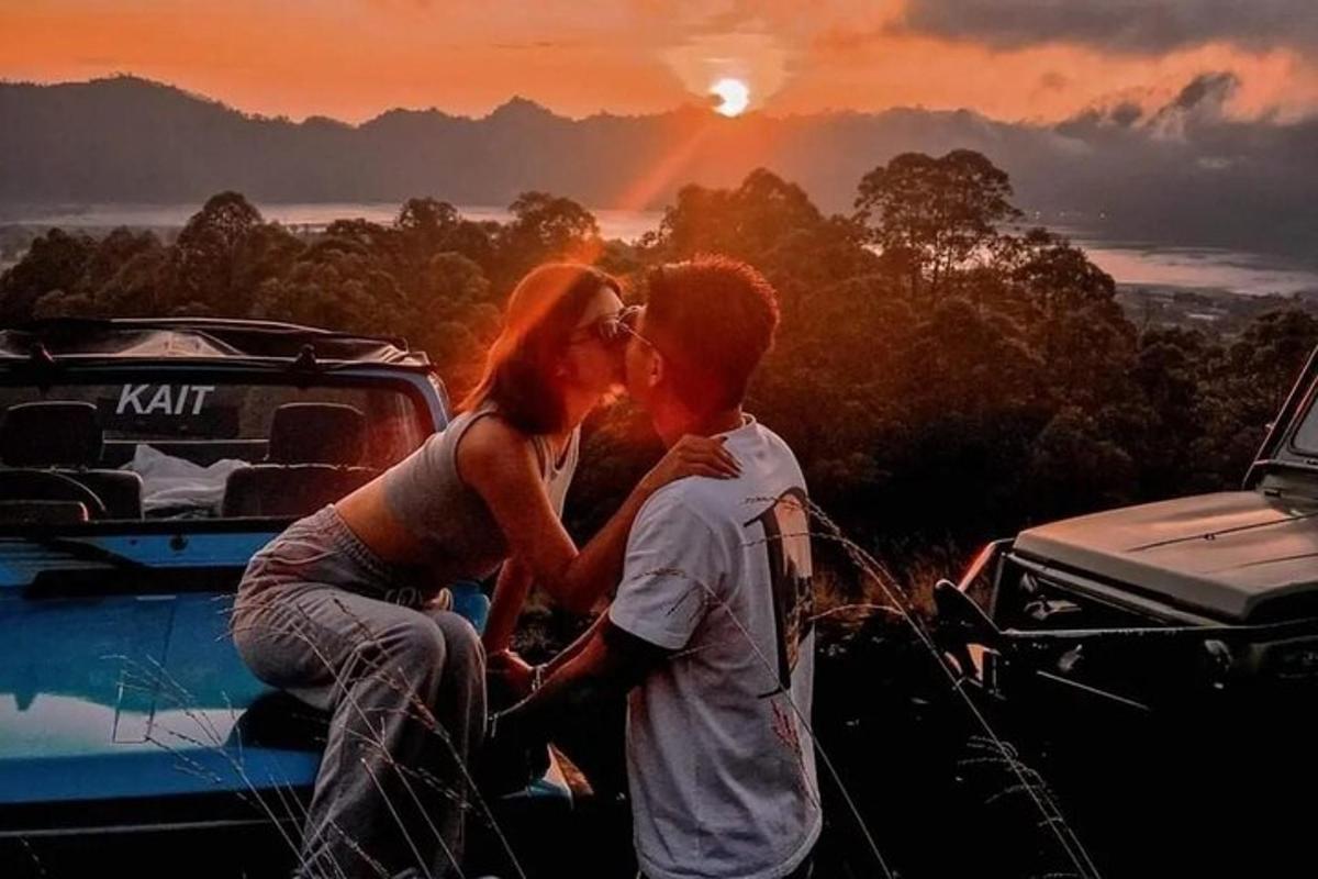 a man and a woman kissing on the hood of a truck