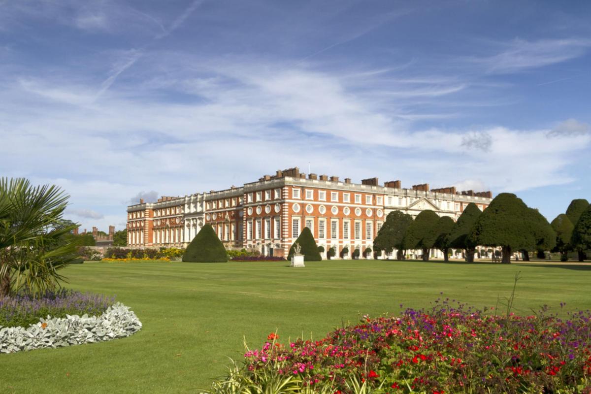 a large building on a green field with flowers