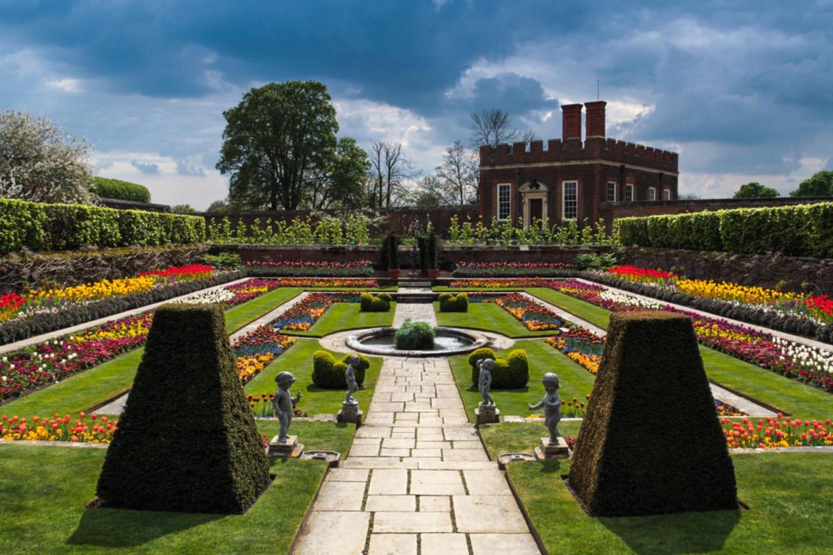 a garden with a fountain in front of a building