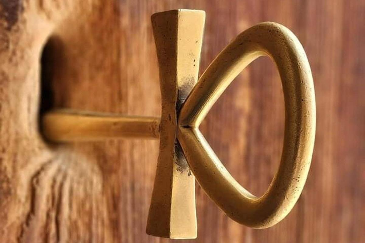 μια ξύλινη πόρτα με έναν μεταλλικό σταυρό πάνω της