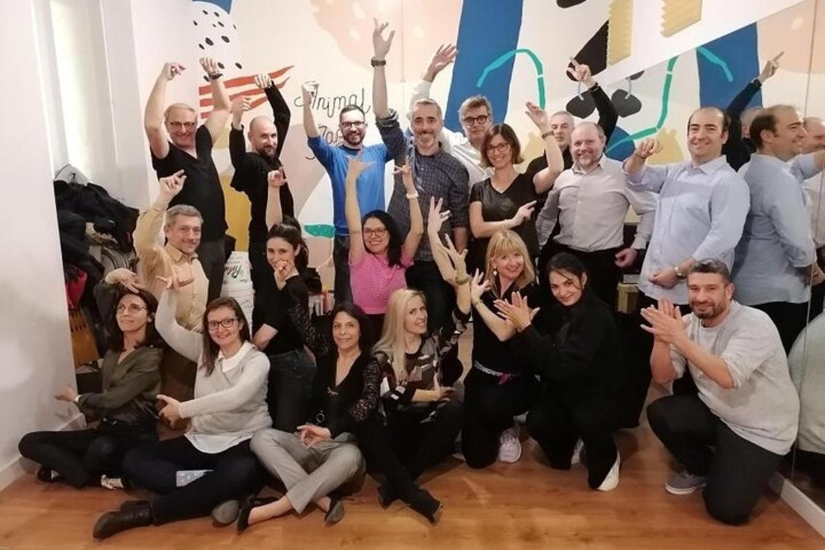 un grup de persones posant per a una foto amb les mans enlaire
